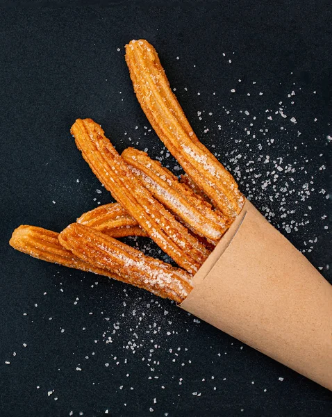 Churro sobre un fondo negro. Cusina tradicional española. Churro. — Foto de Stock