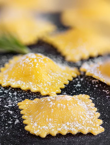 Raviolli with flour and herbs on black background, close up.  It — Stock Photo, Image