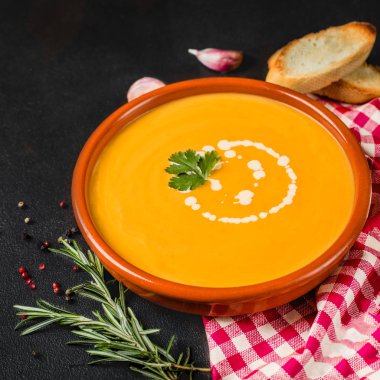 Siyah taş arka planda kabak ve havuç çorbası. Vejetaryen s
