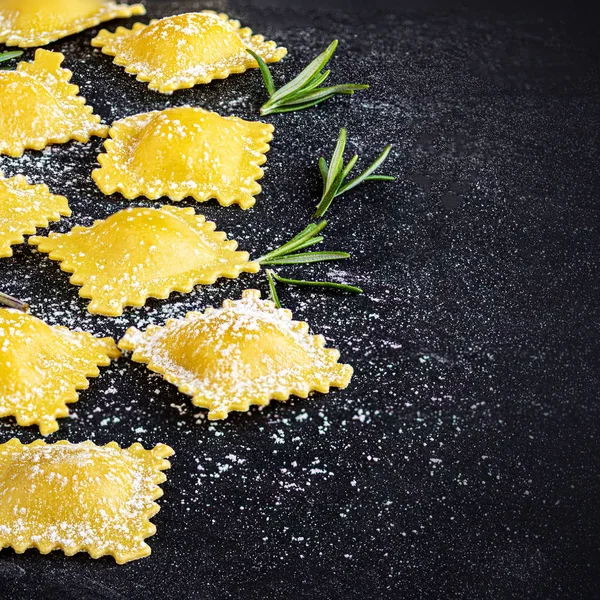 Raviolli met meel en kruiden op donkere achtergrond, Top uitzicht. Cop — Stockfoto