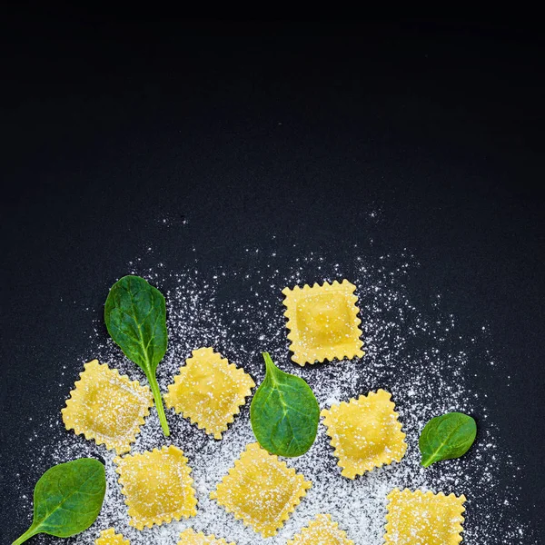 Friss ravioli tészta spenóttal, liszt és gyógynövények a sötét háttérben — Stock Fotó