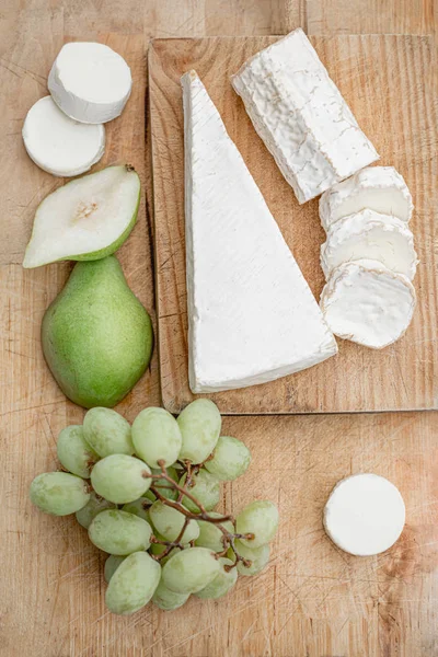 Fresh cheese  with fruits on Wooden board over white background. — Stock Photo, Image