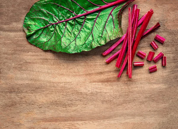 Rhabarber-Gemüse auf Holzboden. frische rote Rhabarberstengel — Stockfoto