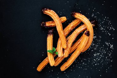 Sırtında şeker ve çikolata sosu olan geleneksel Churros.