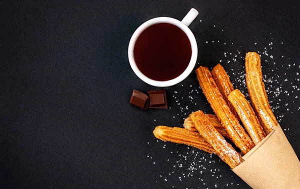 Churros com açúcar e molho de chocolate sobre fundo preto. topo — Fotografia de Stock