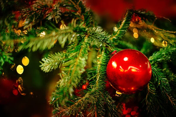 Kerstboom versierd met rode ballen en linten op een blurre — Stockfoto