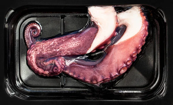 Tentacles of octopus in a vacuum plastic package isolated on whi — Stock Photo, Image