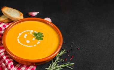 Siyah taş arka planda kabak ve havuç çorbası. Vejetaryen s