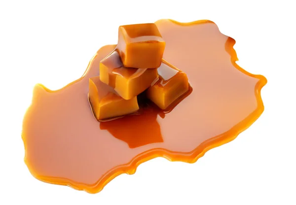 Caramel sauce flowing over caramel candies, isolated on white background. Golden Butterscotch toffee candy close up