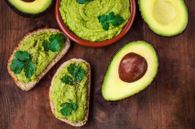 Kırsal ahşap arka planda Avokado Kahvaltısı. Meksika soslu Guacamole avokado tostlu. Boşluğu Kopyala