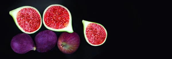 Fresh ripe figs on dark background,  top view. Copy space