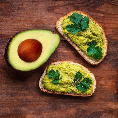 Avokado eski ahşap masada, kopyalama alanı. Avokado sandviçi ve koyu çavdar ekmeği..