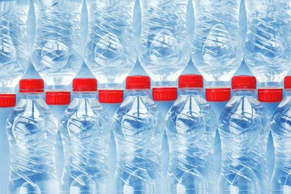 plastic water bottles with red caps isolated on blue background, flat layout