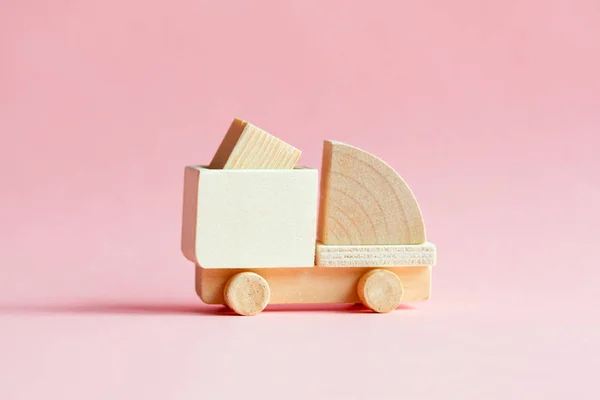 mini wooden cargo truck model with box isolated on pastel pink, creative delivery and transportation concept
