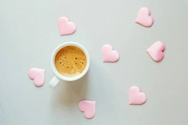 morning cup of coffee and a pink fabric hearts on light background, flat layout, top view, happy morning, romantic, love