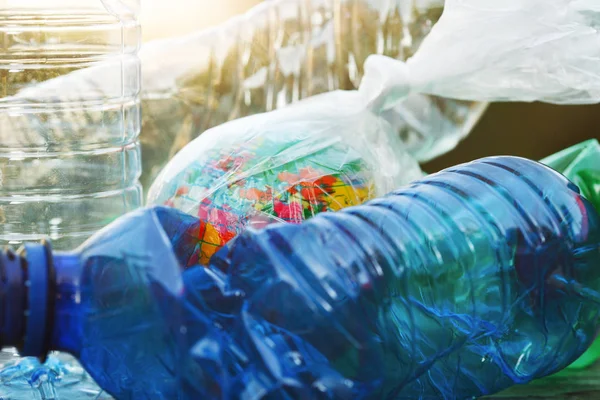 world environment day, earth globe wrapped in transparent plastic bag and  empty used plastic water bottles background, close up