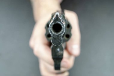 Bir el kamera karşı karşıya varil ile bir tabanca tutuyor. Kamera revolver varil üzerinde odaklanmıştır