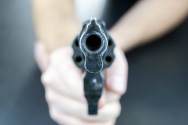 Bir el kamera karşı karşıya varil ile bir tabanca tutuyor. Kamera revolver varil üzerinde odaklanmıştır