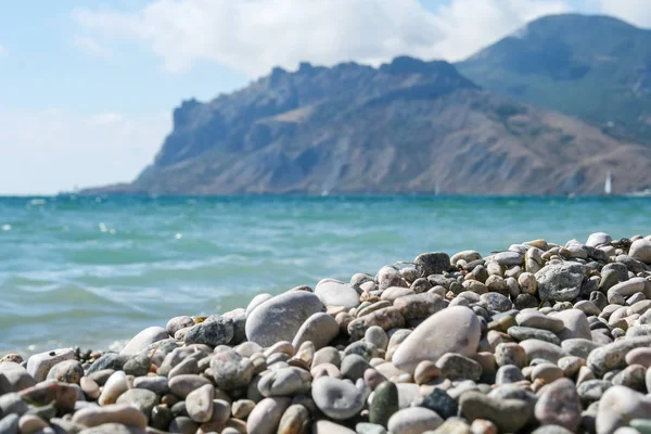 Karadeniz kıyısında bulanık dağlar ve deniz karşı çakıl taşları ile — Stok fotoğraf