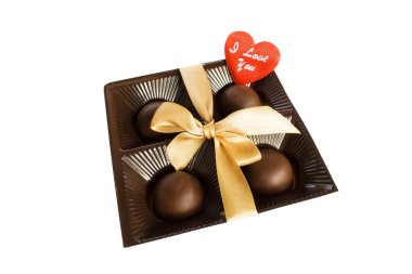 Beyaz bir arka planda bir aşk yazıt ile bir yay ve küçük kırmızı kalp ile sarı bir şerit ile bağlanmış bir plastik kare kutuda dört yuvarlak çikolata şekerler