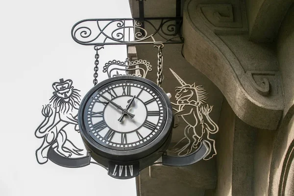Relógio de metal urbano de rua com figuras de um leão e um unicórnio na cidade de Lviv, Ucrânia — Fotografia de Stock