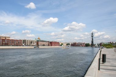 Moskva Nehri'nin nehir yürüyüşü, tekneler boyunca yelken ile, diğer tarafta evler, bulutlar ile mavi gökyüzü ve Uzak Çar Peter Anıtı