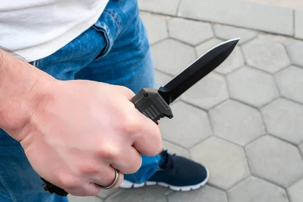 Чоловік у блакитних джинсах і біла футболка з чорною кишенею передній ніж у руці — стокове фото