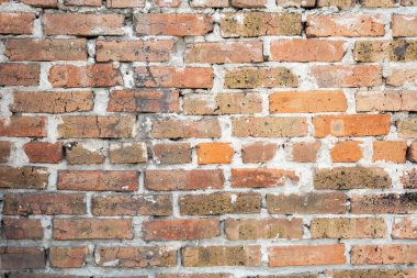 Eski turuncu duvarlar çatlamış tuğlalar arasında kalın bir çimento tabakası var.