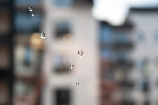 Drops of water on the window glass against a blurred house on a rainy day — Stock Photo, Image