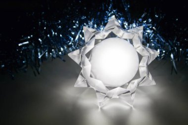 Mavi bir çelenk arka planda yatan parlayan bir yıldız