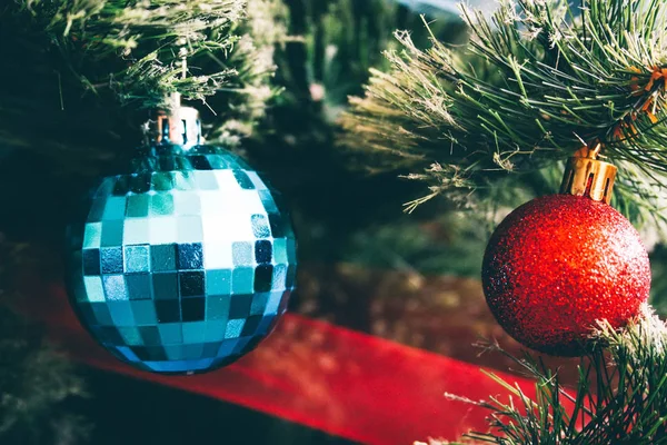 Blue and red balls hang on an artificial Christmas tree