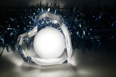 Mavi bir çelenk arka plana karşı yatan parlayan bir kalp