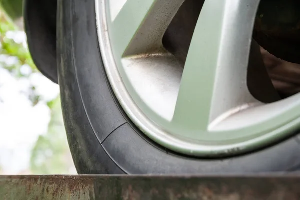 Vue rapprochée d'une vieille roue de voiture sale avec des pneus d'hiver et un disque de frein argenté. Concentration sélective — Photo