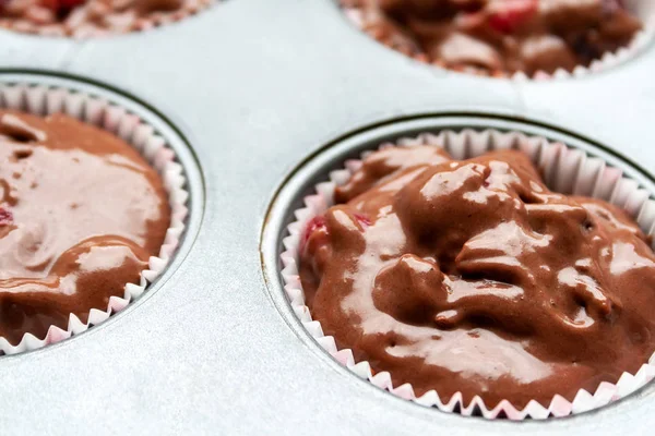 Oluklu kenarları ile kağıt muffin kalıpları Closeup görünümü, pişirme çanak kiraz ile çikolata hamuru ile dolu. Fırına yüklemeden önce kek pişirmeden önce hazırlık — Stok fotoğraf