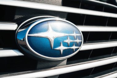  Radyatör ızgarasında Subaru amblemi. Mavi arka planda gümüş yıldızlar. Yan görünüm