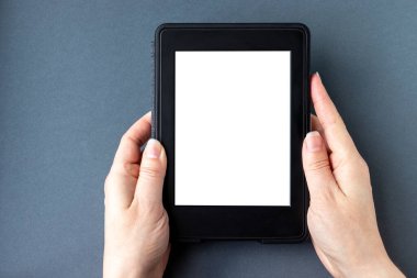 Gri bir arka planda beyaz, boş ekranlı, kadın eli yazılı modern siyah bir elektronik kitap. Model tableti kapat