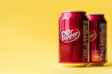 Kyiv, Ukrayna - 3 Haziran 2020: İki kırmızı kutu Dr. Pepper parlak sarı arka planda içiyor. Kopyalama alanı ile yakın görünüm