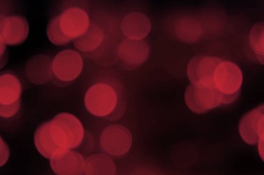 Bulanık ışıklar koyu kırmızı, siyah arkaplan. Soyut Bokeh. Parlak, neşeli, gizemli doku.