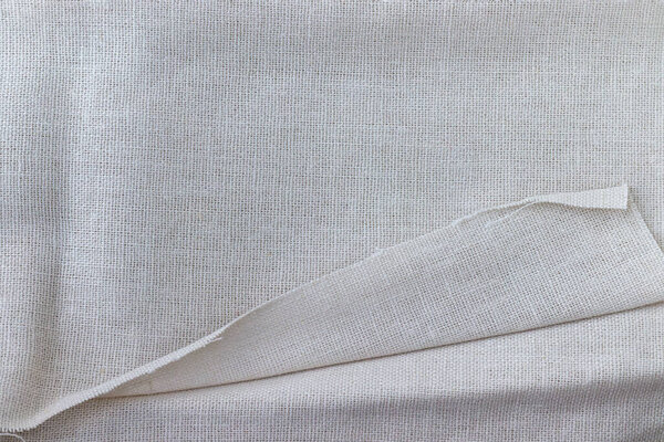 Textural background of soft natural linen fabric. Closeup view