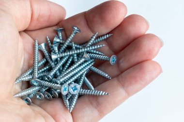 İnsan avucunda metal vidalar var. Seçici odaklanma. Yakın görünüm