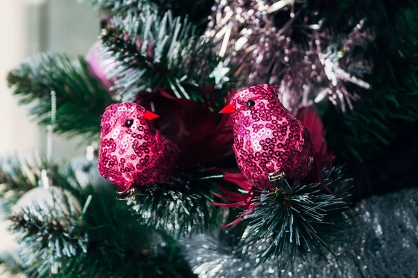 人工のクリスマスツリーにキラキラと輝くピンクの織物の鳥2羽 選択的フォーカス 大晦日の装飾が施されたホリデーカード — ストック写真