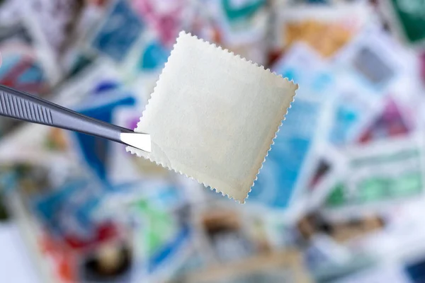 Blanco Vierkante Postzegel Tegen Wazige Achtergrondverzameling Van Veelkleurige Postzegels Uit — Stockfoto