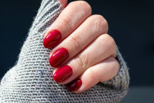 Kobieca Ręka Szarej Dzianinie Sweter Tkaniny Pięknym Błyszczącym Manicure Bordowy — Zdjęcie stockowe