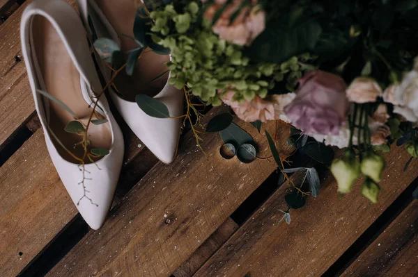 Düğün ayakkabıları ve masada buket düğün altın alyans,