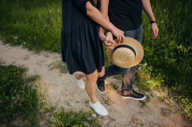 Mutlu çift güzel romantik gün batımında arka planda güneş batan ellerinden kalp sembolü yapma.