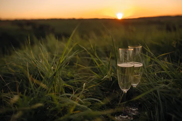Gün batımına karşı beyaz şarap renkli günbatımı Bardaklar plajda oturan şarap romantik bir bardak