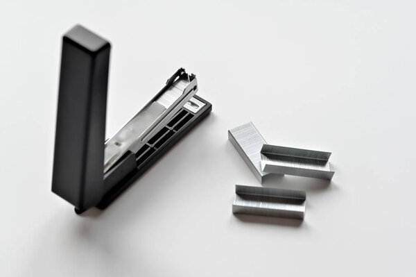 Stapler black with paper clips isolated on white background.