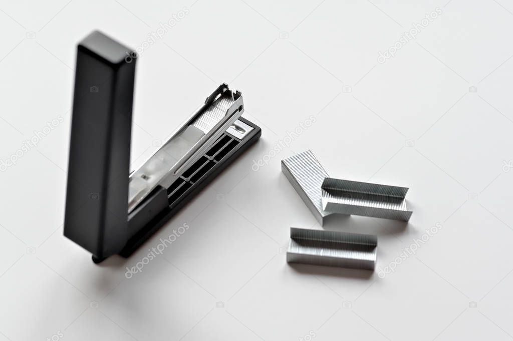 Stapler black with paper clips isolated on white background.