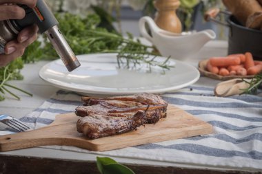 Erkek el ahşap tahta üzerinde kuzu biftek kızartma görünümü Kapat.