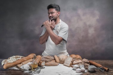 Adam masada ekmek büyük bıçak ile tıraş.